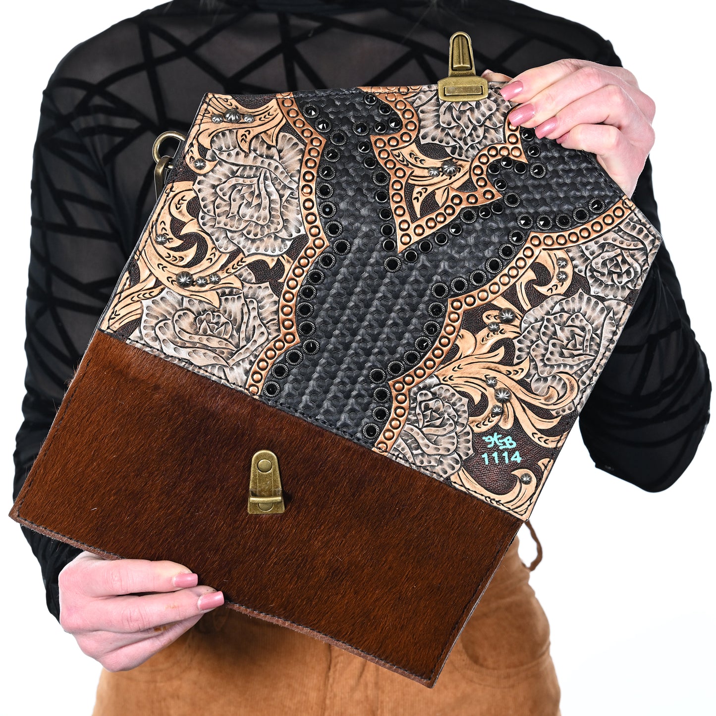 
                  
                    A person holding an Heritage Brand nola clutch #1114 with a combination of textured, embossed designs and a furry lower half.
                  
                