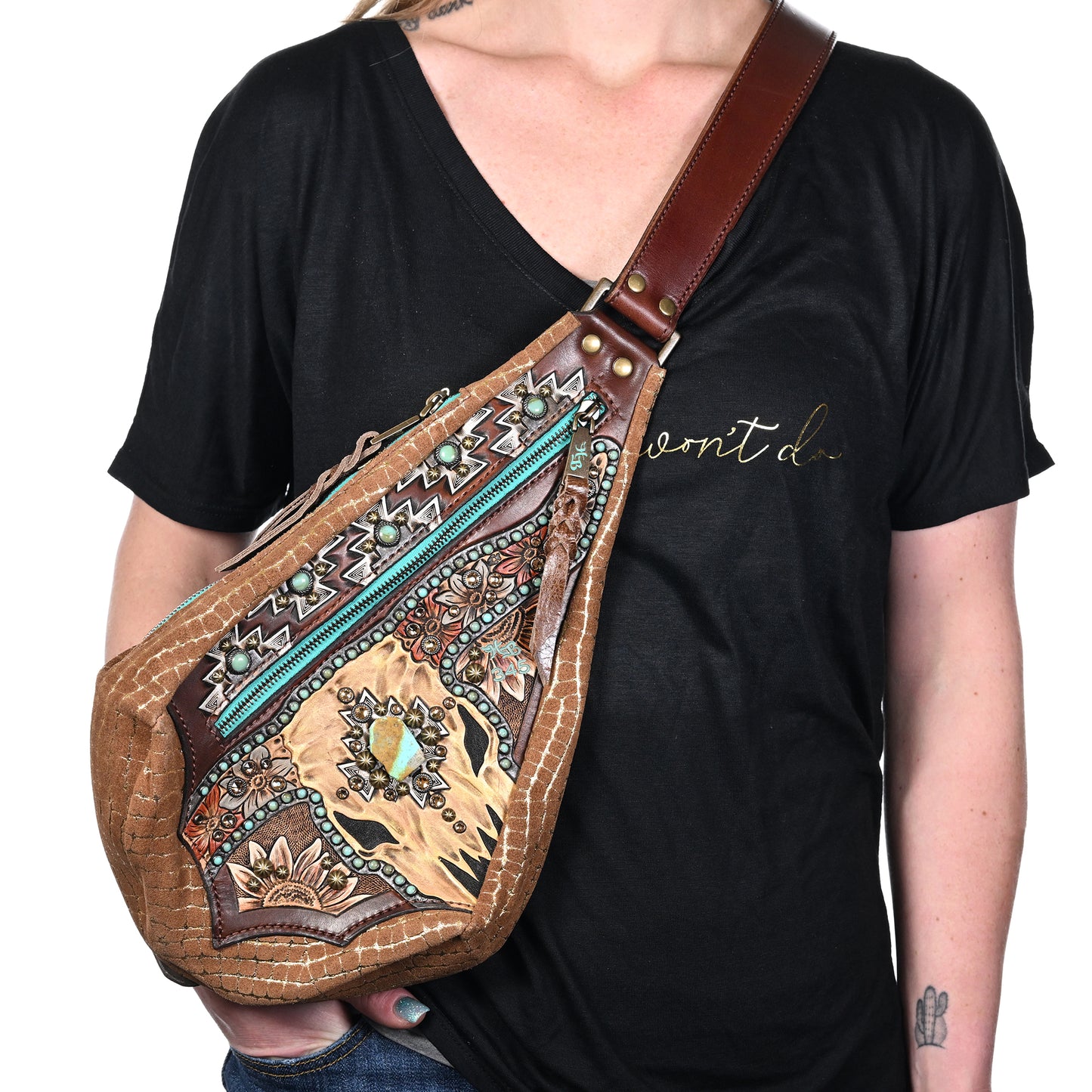
                  
                    A person wearing a black t-shirt with cursive text displaying a large, patterned Heritage Brand fyra bag #345.
                  
                