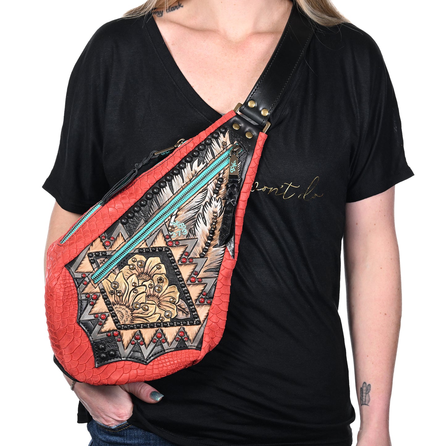 
                  
                    Woman wearing a black v-neck t-shirt and showcasing a Heritage Brand fyra bag #373.
                  
                