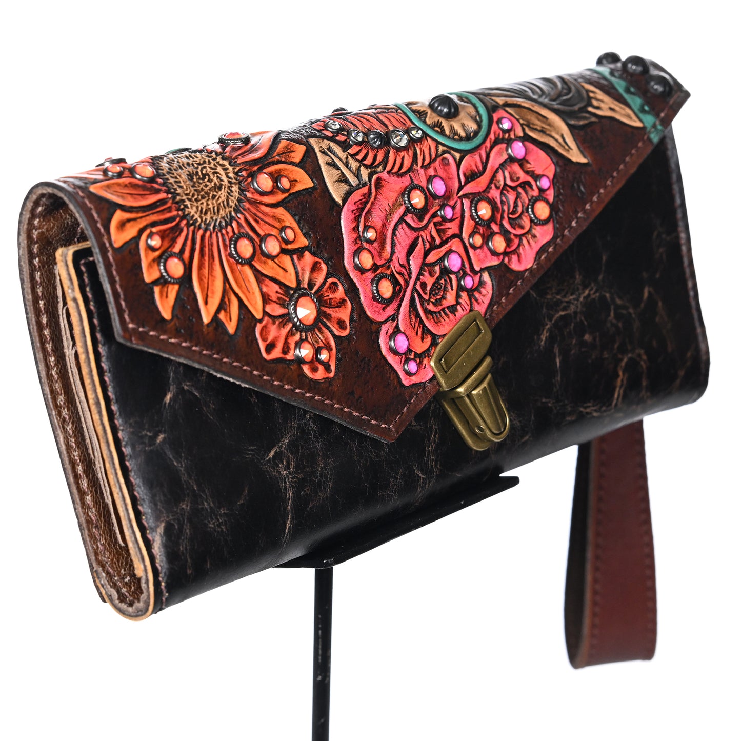 A decorative nola clutch #708 with floral embossing and colorful accents on a stand by Heritage Brand.