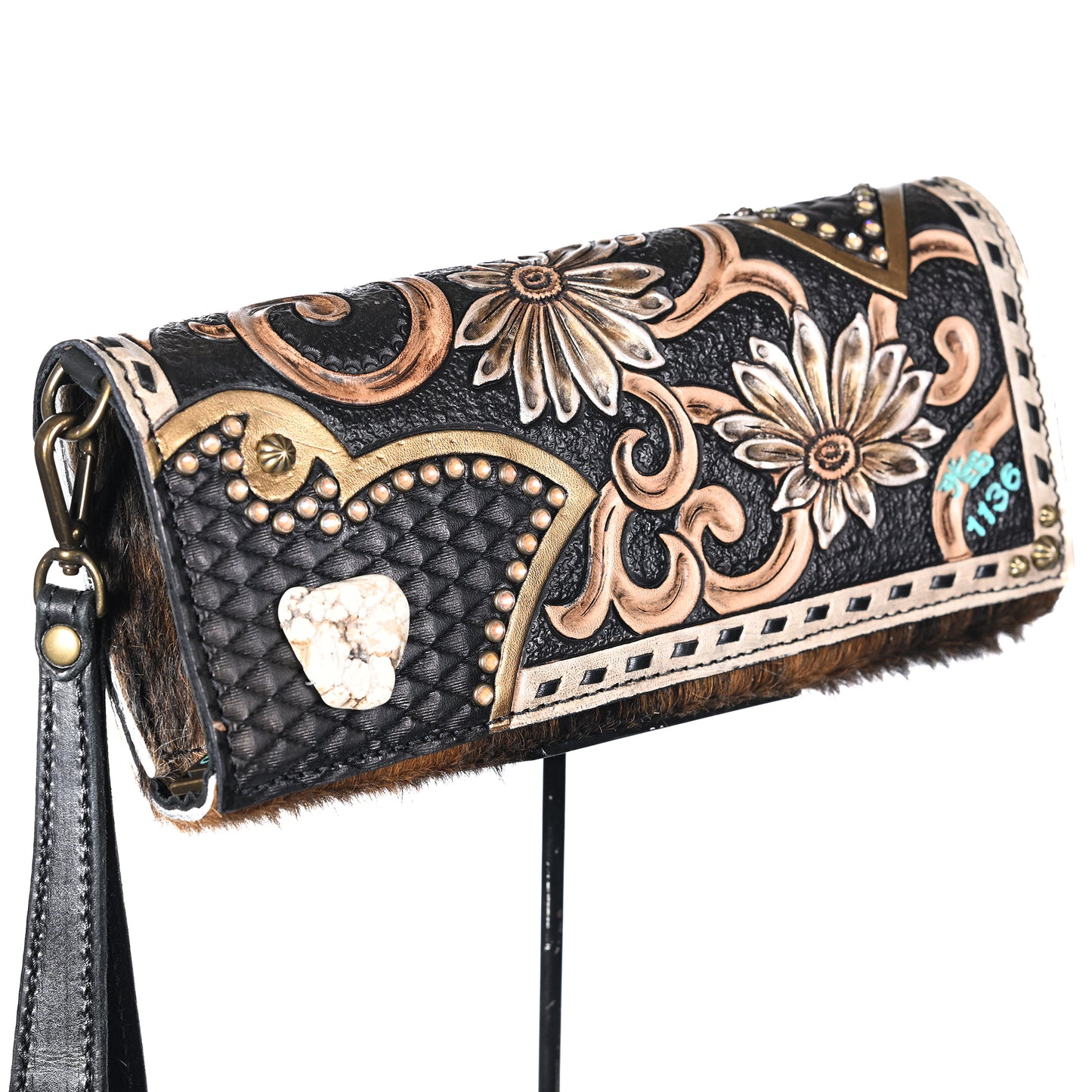
                  
                    An intricately designed Heritage Brand nola clutch #1136 with floral patterns and a distinctive stone embellishment.
                  
                