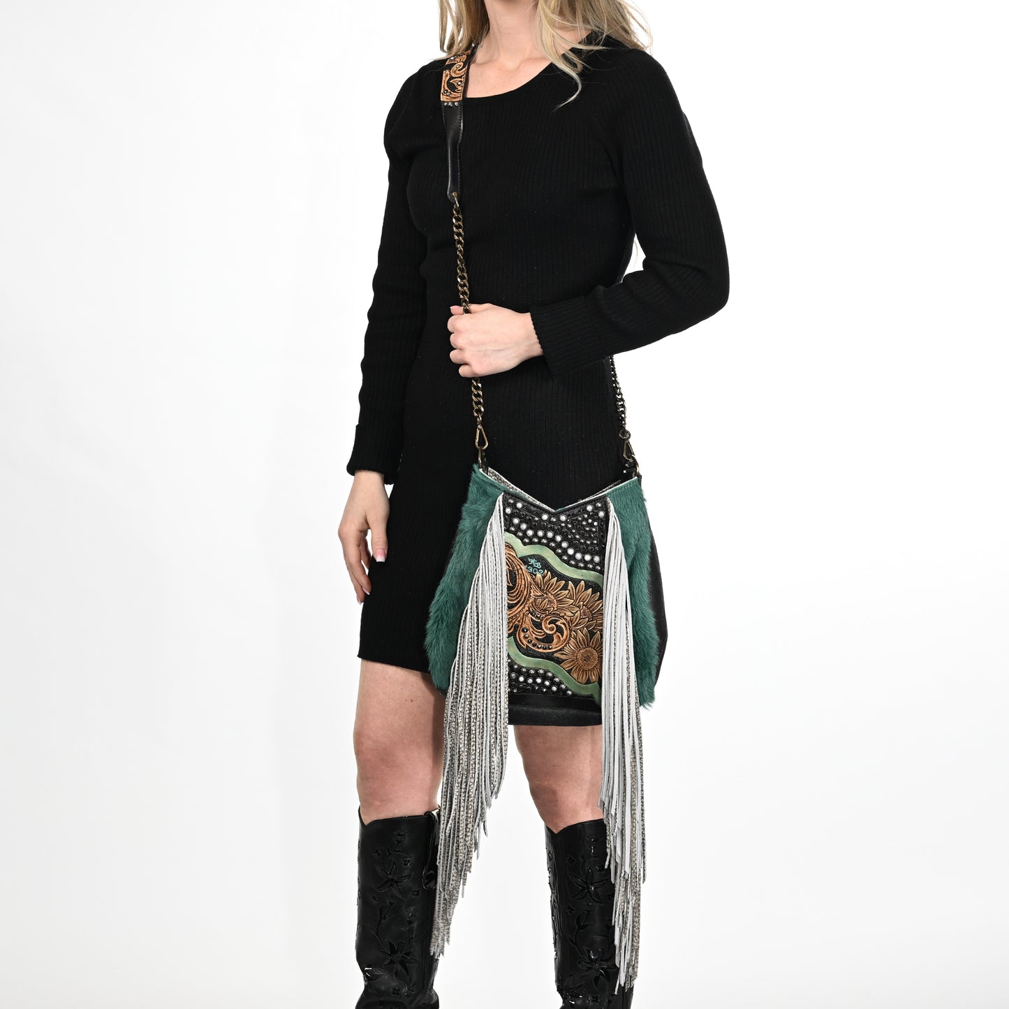 
                  
                    Woman posing in a black outfit with a decorative green scarf and black glasses cases, holding a Heritage Brand lyrik bag #1302.
                  
                