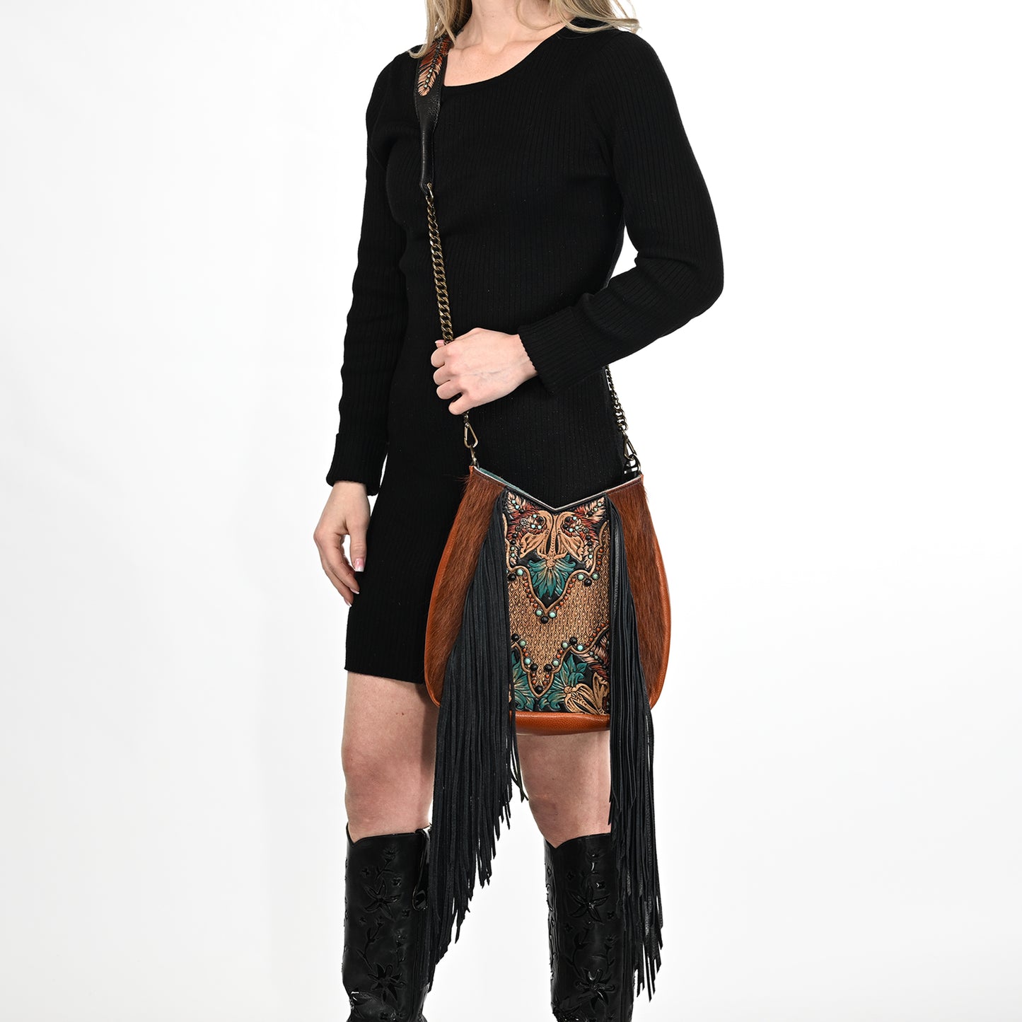 
                  
                    Woman posing in a black dress and glasses cases, carrying a Heritage Brand lyrik bag #1286 with decorative patterns.
                  
                