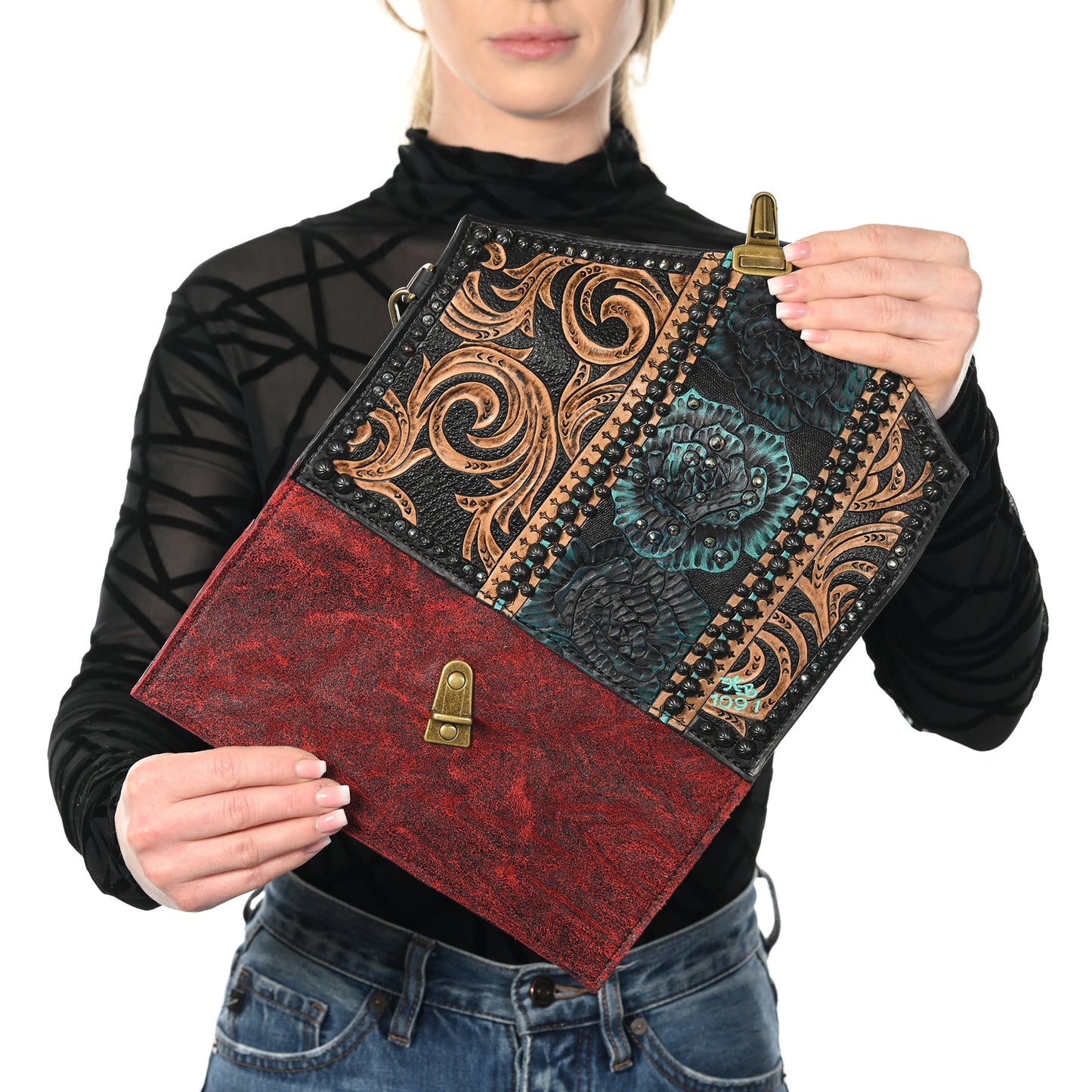 
                  
                    A person presenting an ornate, vintage-style nola clutch #1091 from Heritage Brand with a decorative cover.
                  
                
