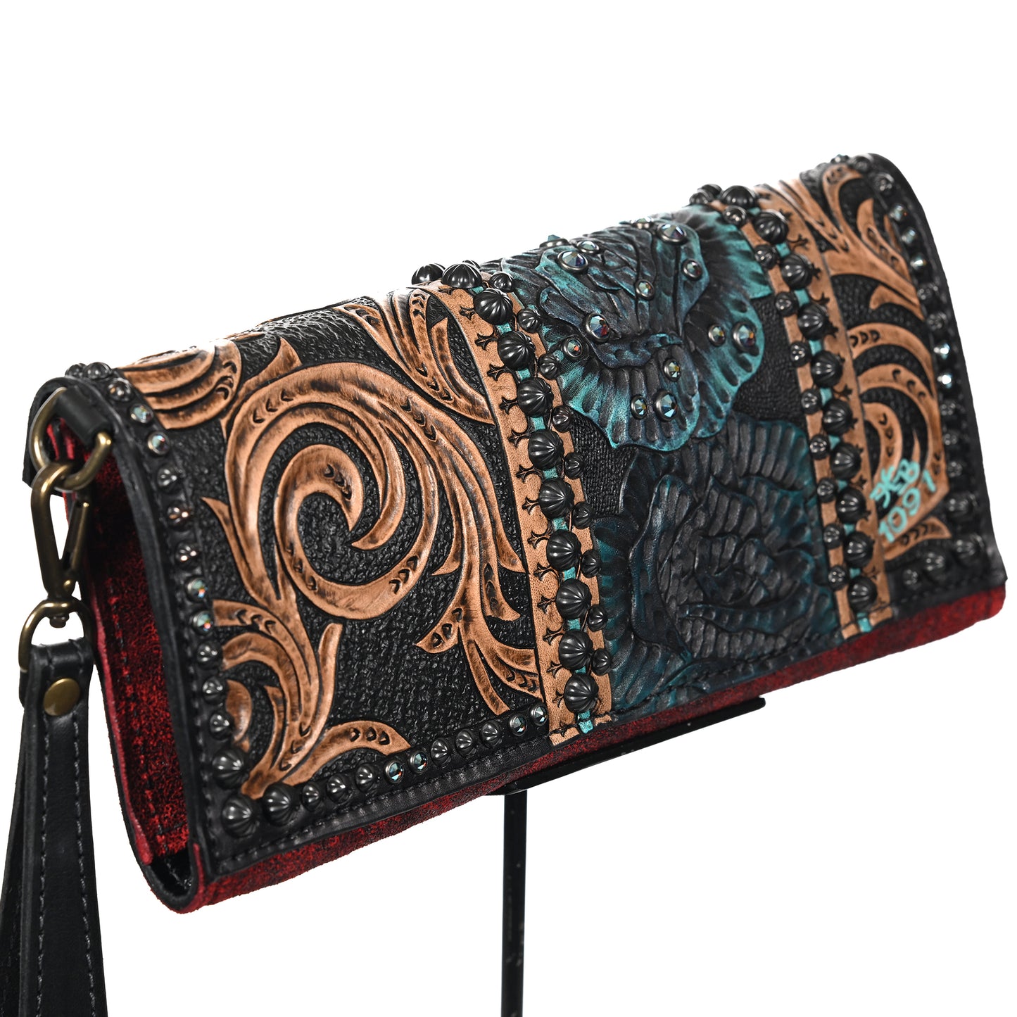 
                  
                    Heritage Brand nola clutch #1091 with embossed floral and paisley designs, accented with metallic highlights and studded embellishments, against a white background.
                  
                