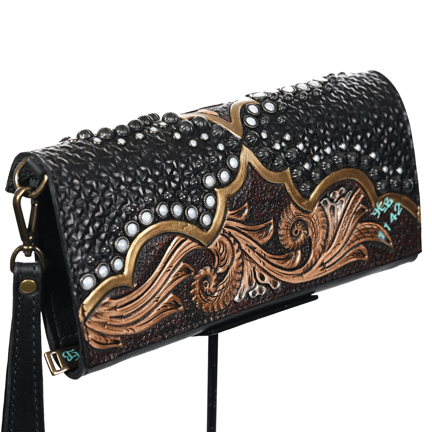 
                  
                    Heritage Brand's nola clutch #1142 with a decorative pattern and a shoulder strap.
                  
                