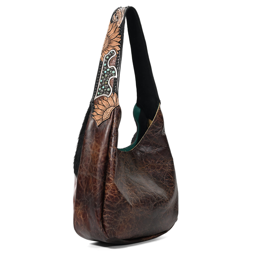 
                  
                    A brown leather Heritage Brand Marilyn Bag #5125 with a patterned strap isolated on a white background.
                  
                