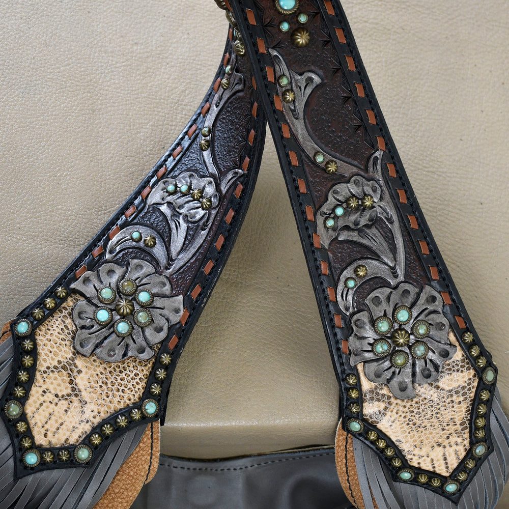 
                  
                    Close-up of ornately decorated Heritage Brand leather sandals with floral patterns and metallic studs.
                  
                