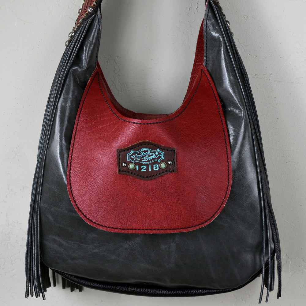 
                  
                    Black and red leather Marilyn bag #6 with fringes and a metallic logo plaque by Heritage Brand.
                  
                