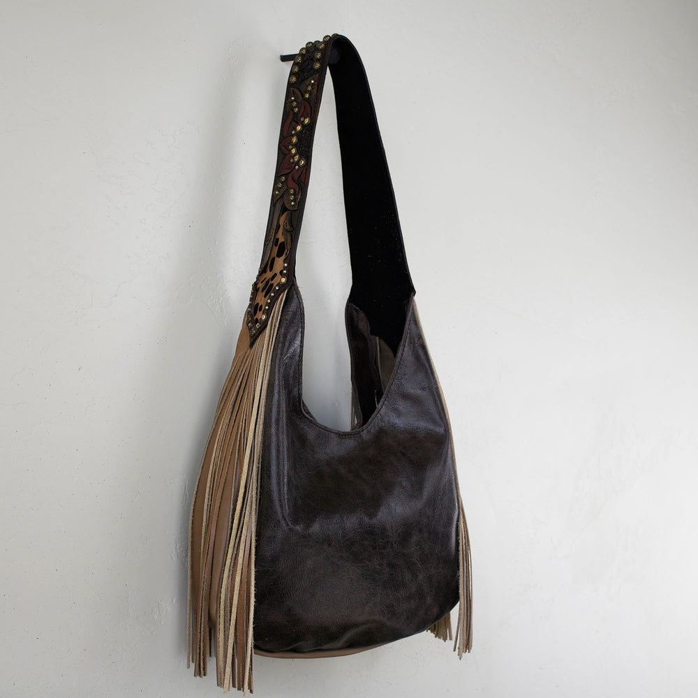 Marilyn bag #17 by Heritage Brand with fringe decoration hanging on a white wall.