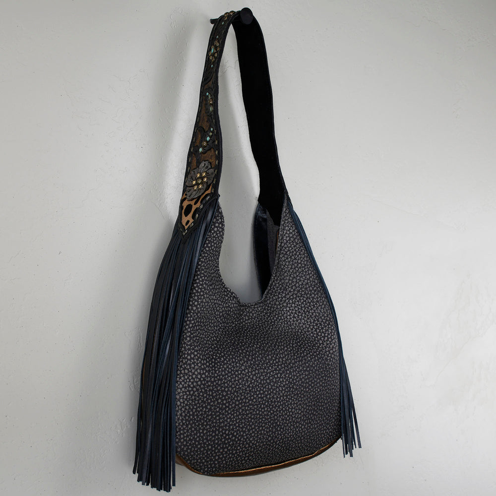 A Heritage Brand marilyn bag #24 with a black strap and tassel detail against a white background.