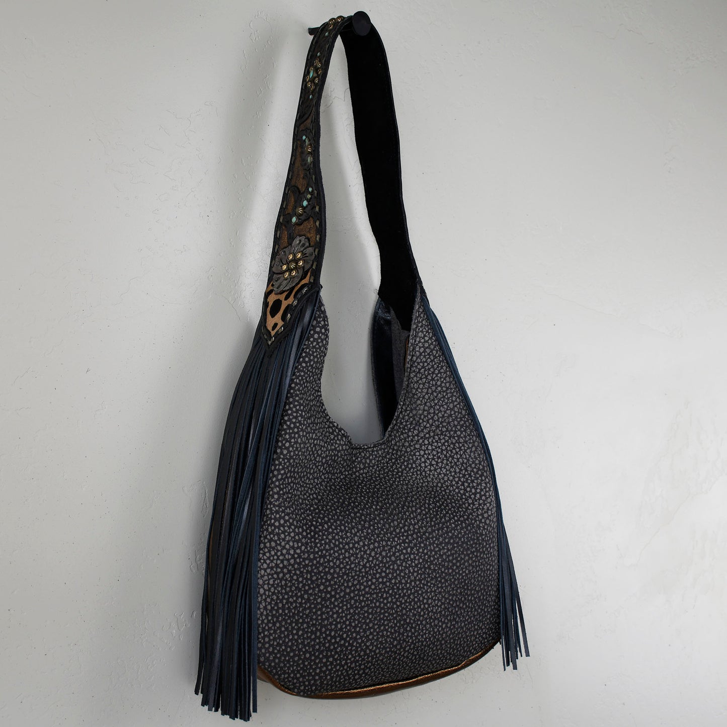 
                  
                    A Heritage Brand marilyn bag #24 with a black strap and tassel detail against a white background.
                  
                