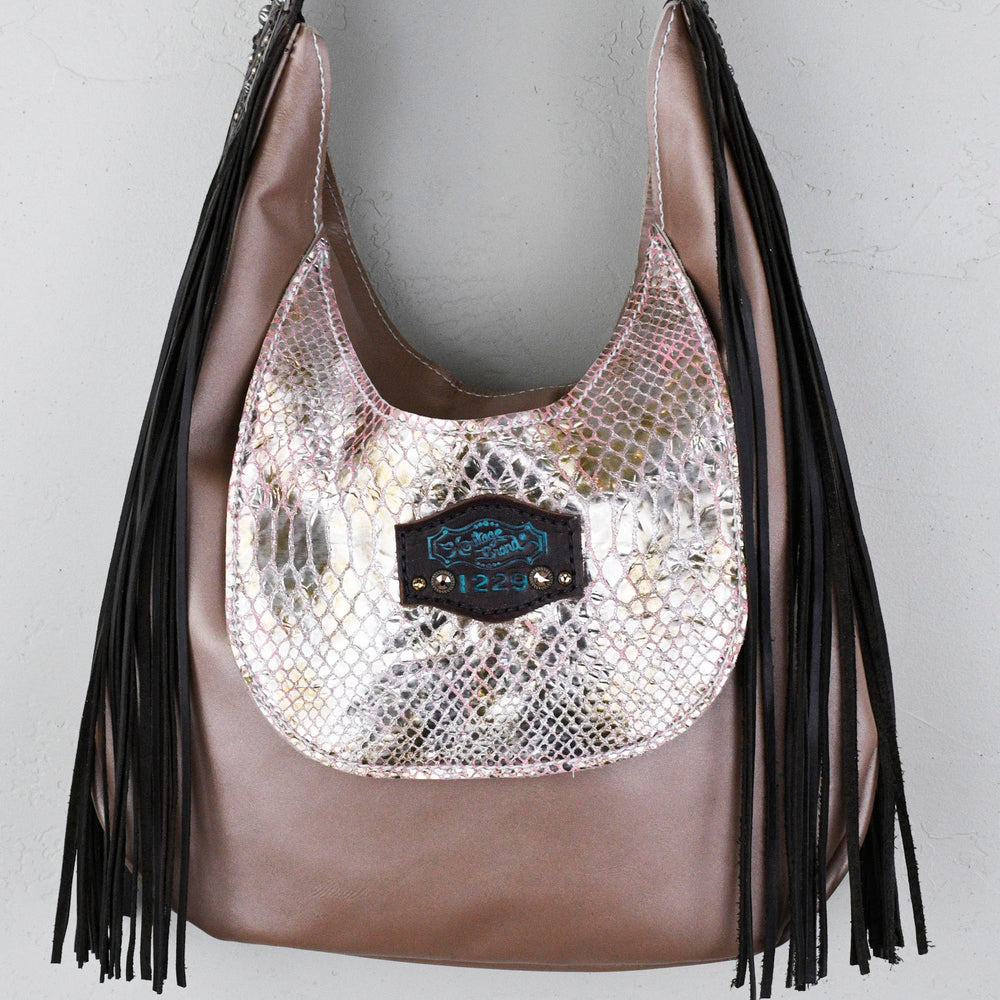 
                  
                     Metallic marilyn bag #35 with fringe detailing and a central embossed label by Heritage Brand.
                  
                