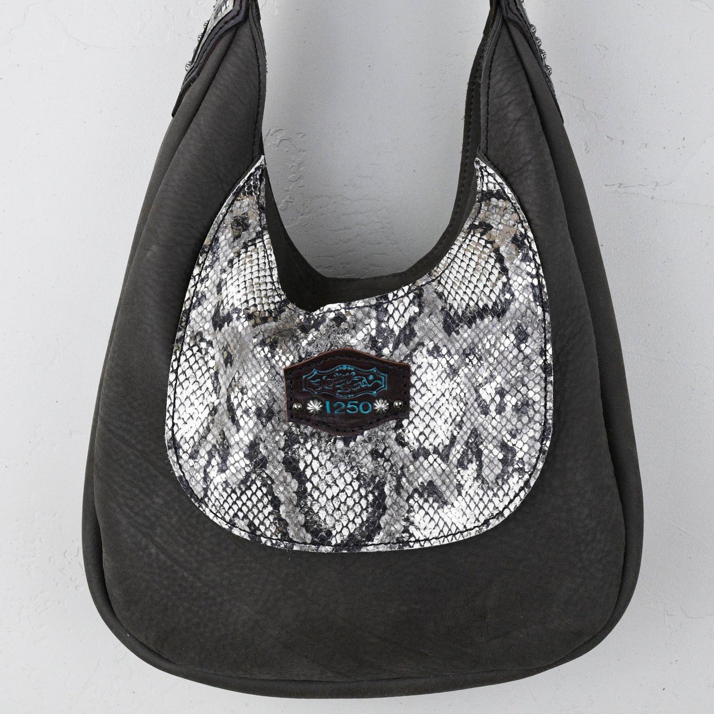 
                  
                    Replace "Black and silver hobo handbag with a snake skin pattern" with "Marilyn Bag #37 by Heritage Brand.
                  
                