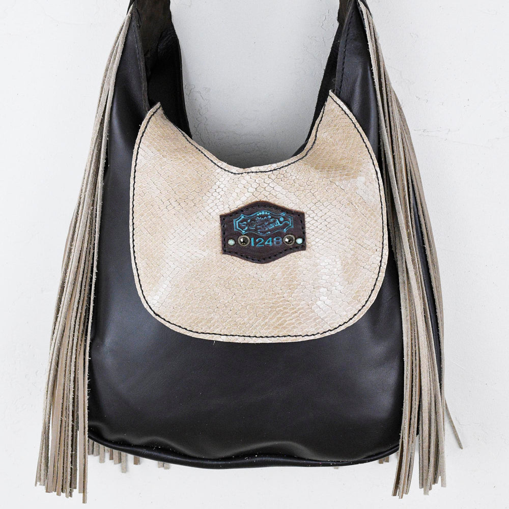 
                  
                    Black and beige Marilyn bag #1248 by Heritage Brand with fringes and a metallic detail.
                  
                