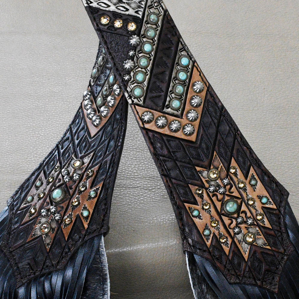 
                  
                    Close-up of ornately decorated Heritage Brand belts with embossed designs and studded with stones and metal embellishments.
                  
                