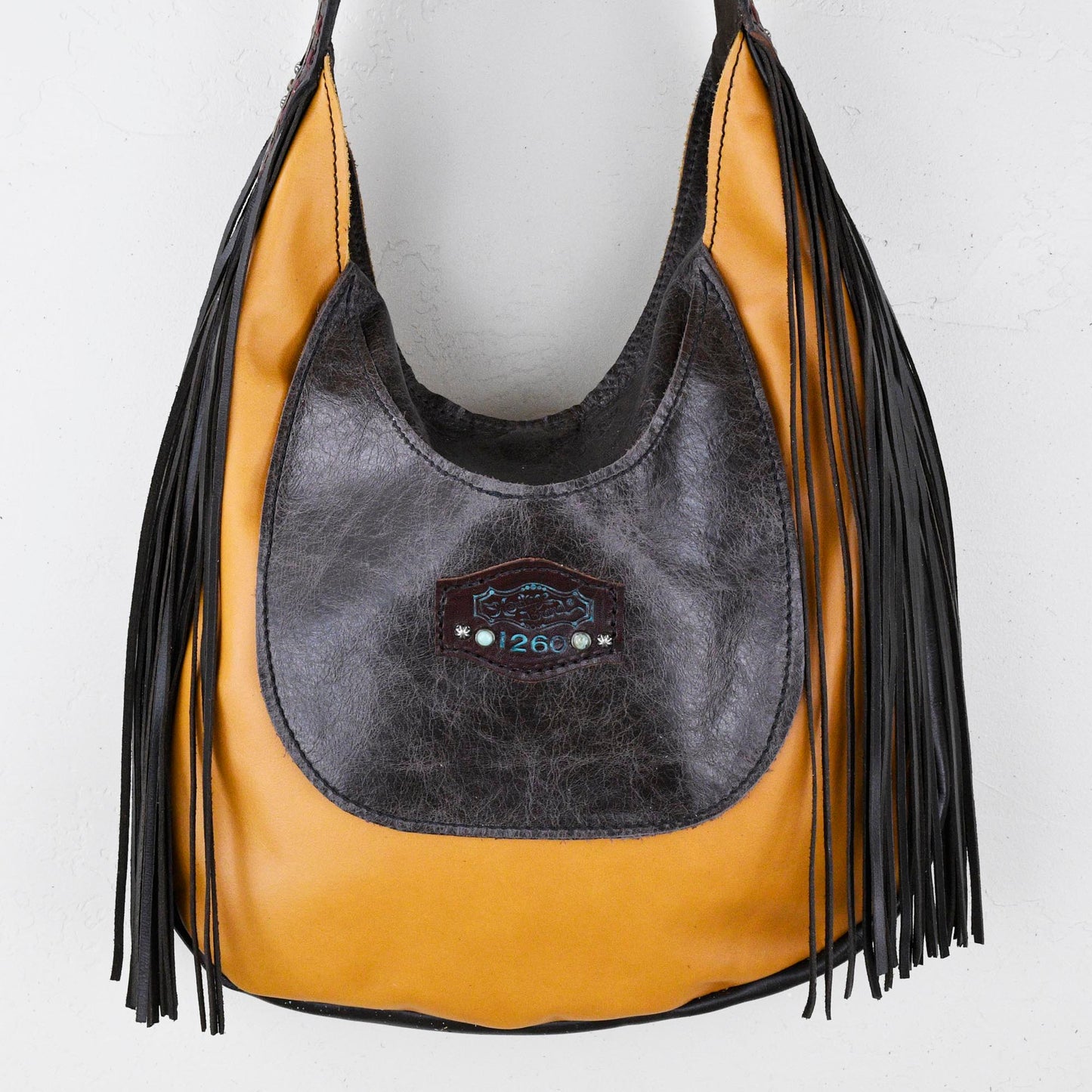 
                  
                    Two-tone leather Marilyn bag #1260 with fringe detail displayed on a white background by Heritage Brand.
                  
                