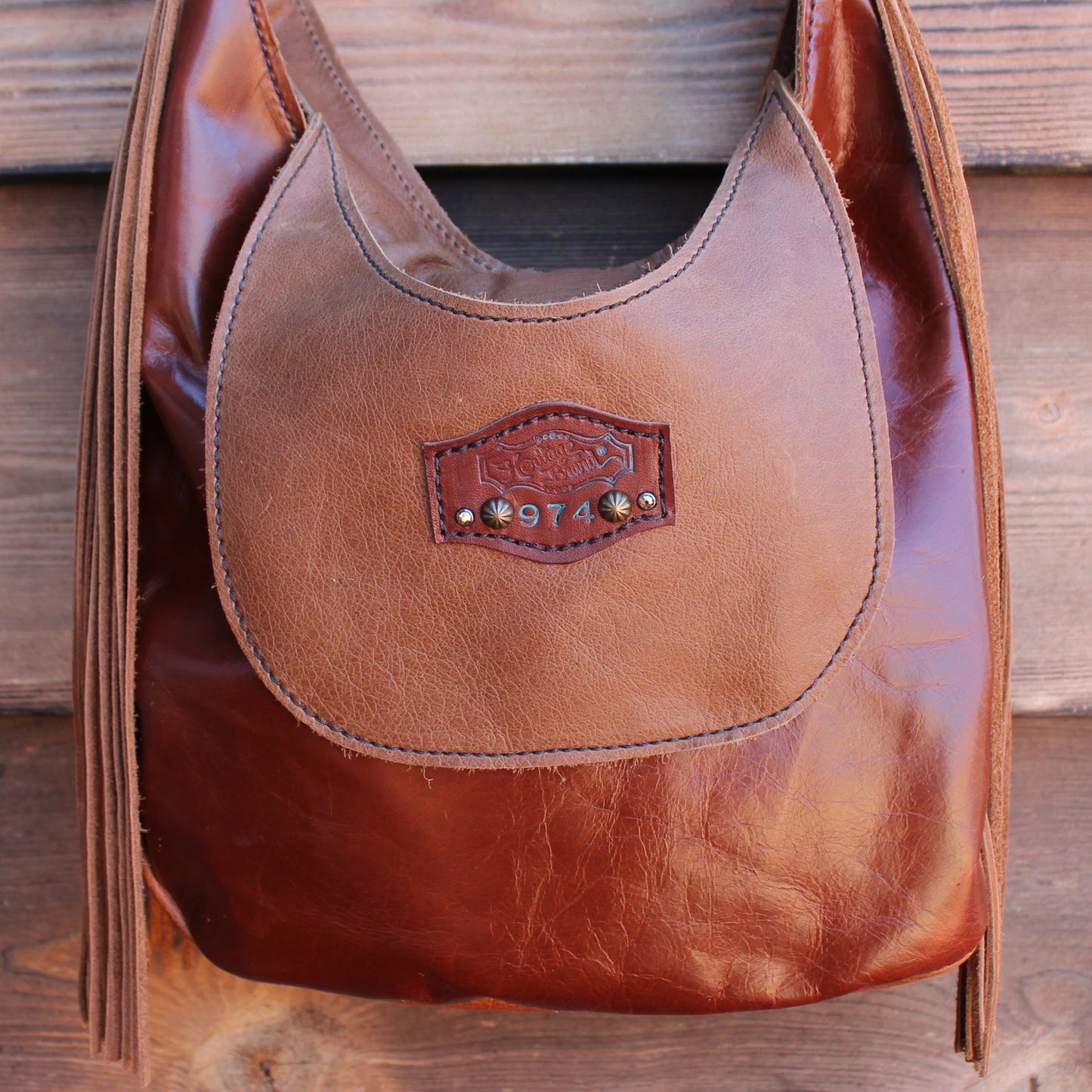 
                  
                    Brown leather marilyn bag #974 by Heritage Brand with a branded emblem.
                  
                