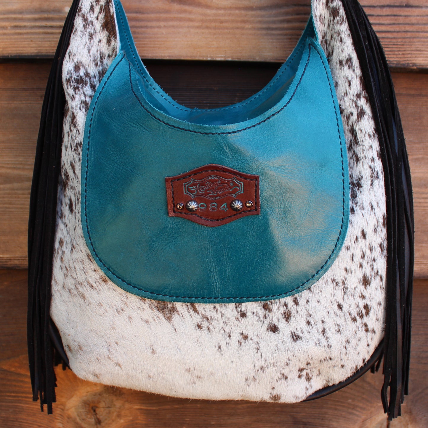 
                  
                    Blue and white leather "Marilyn Bag #984" handbag with fringe and cowhide pattern by Heritage Brand.
                  
                