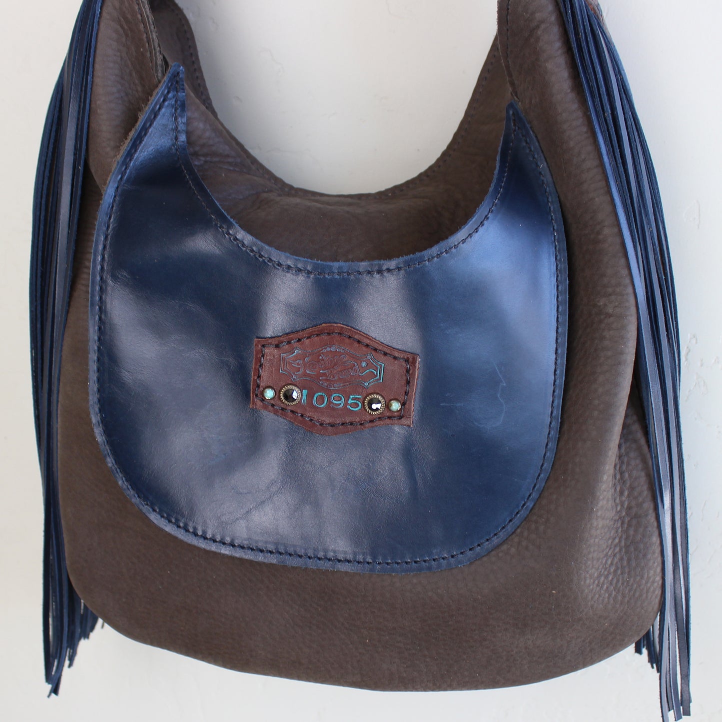 
                  
                    Navy blue leather Marilyn bag #1095 with fringe details and a Heritage Brand label.
                  
                