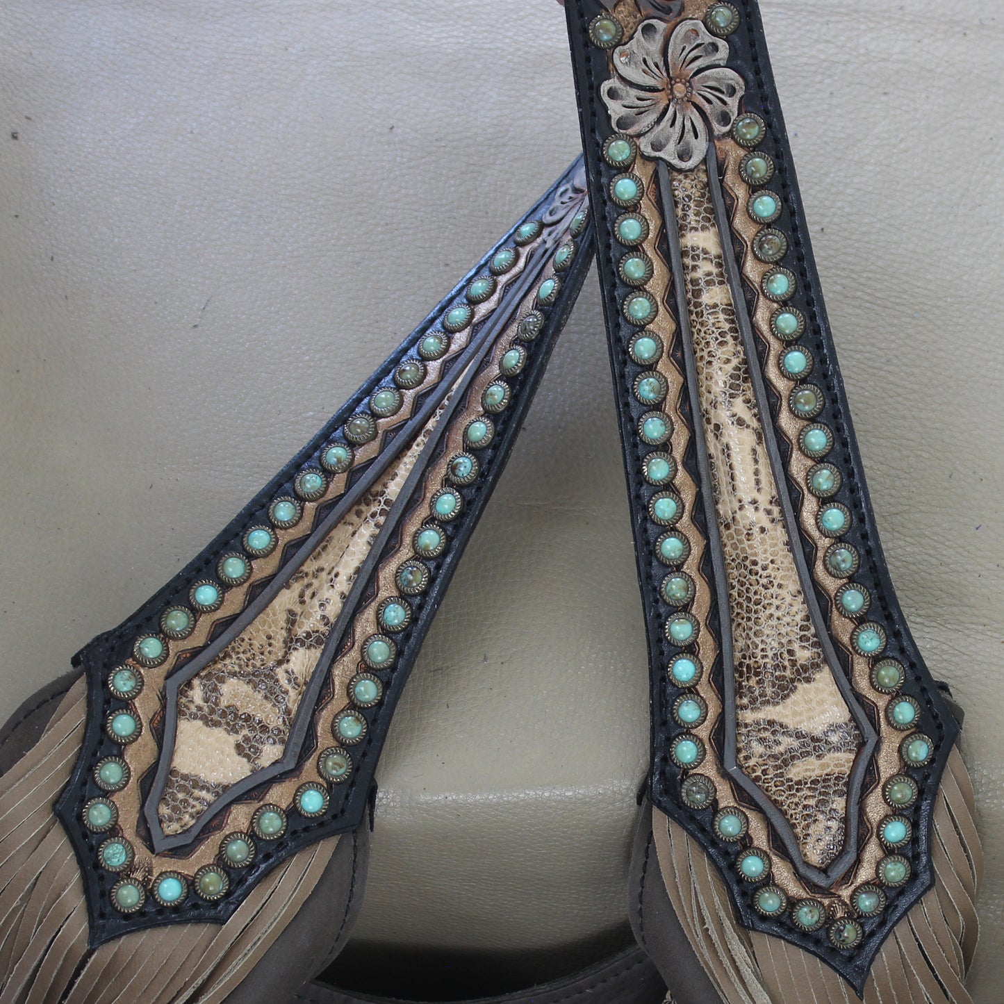 
                  
                    Close-up of ornate Heritage Brand glasses cases with turquoise inlays and stitched detailing.
                  
                
